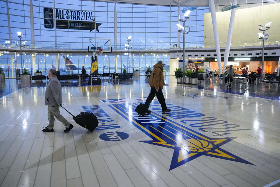 FILE - Travelers using Indianapolis International Airport make their way across a replica of the court that will be use for the NBA All-Star game Thursday, Jan. 18, 2024. Authorities have created a full-size replica basketball court with two baskets, one equipped with a short clock, to promote Indy's first All-Star Game since 1984. This All-Star weekend in Indianapolis was supposed to happen in 2021, before a pandemic got in the way. (AP Photo/Michael Conroy, File)