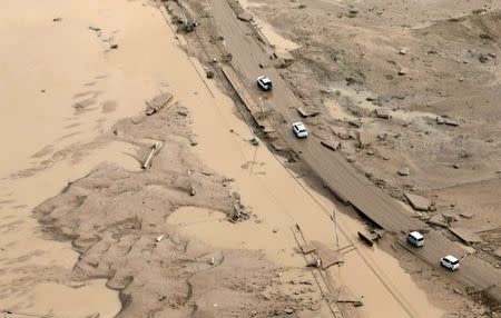 FILE PHOTO: Cars move along a road covered with mud after heavy rain in Mabi town in Kurashiki, Okayama Prefecture, Japan,in this photo taken by Kyodo July 9, 2018. Mandatory credit Kyodo/via REUTERS/File Photo