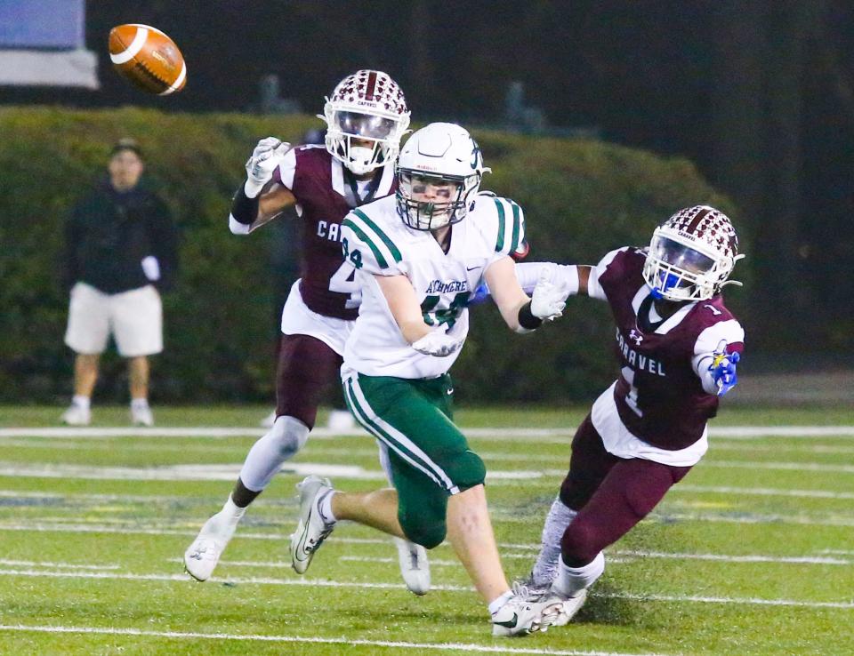 Caravel's Vandrick Hamlin (left) and Charles Broadard defend a pass to Archmere's Brendan Burke late in the fourth quarter of Caravel's 35-13 win in the DIAA Class 2A championship at Delaware Stadium, Saturday, Dec. 2, 2023.