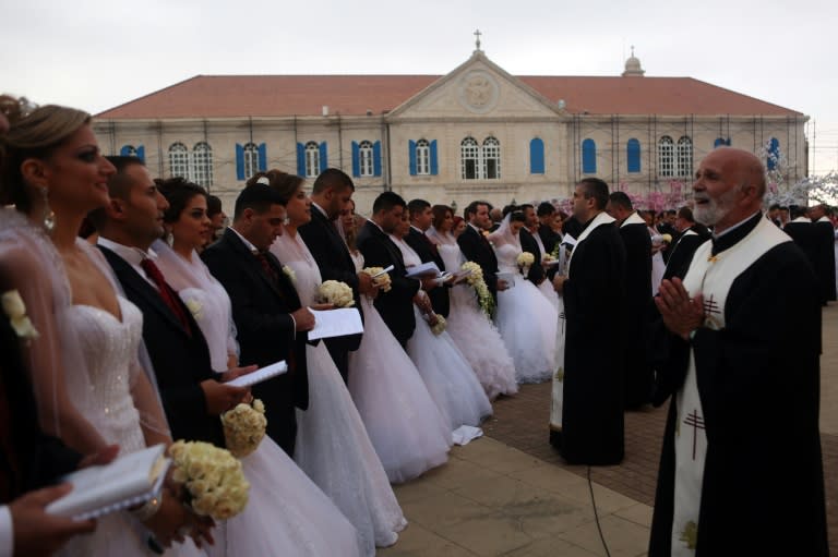 Lebanese Maronite Christian Catholic priests bless Lebanese Christian couples taking part in a mass wedding at the Maronite Patriarchate in Bkerke on September 6, 2015