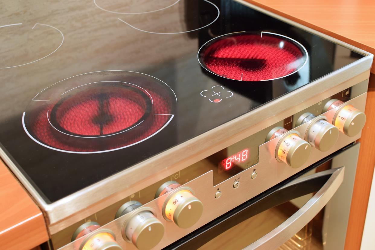 An electric ceramic stove with two burners on. 