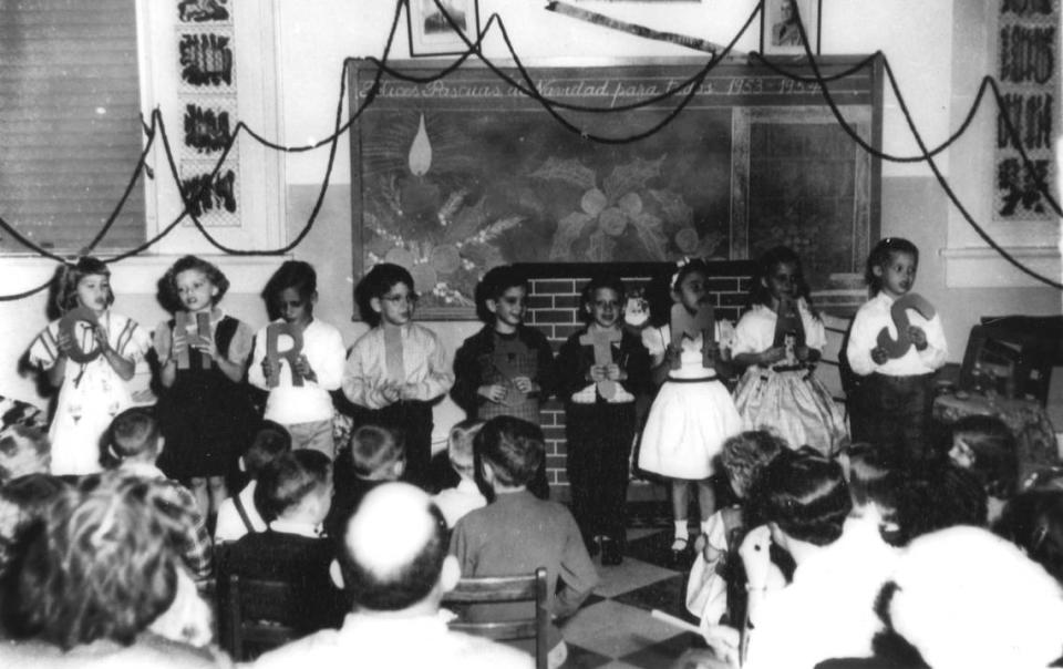 Los niños de la Escuela San Carlos (ahora Instituto San Carlos) de Cayo Hueso sostienen su mensaje navideño ante un público encantado durante su obra de Navidad de 1954.