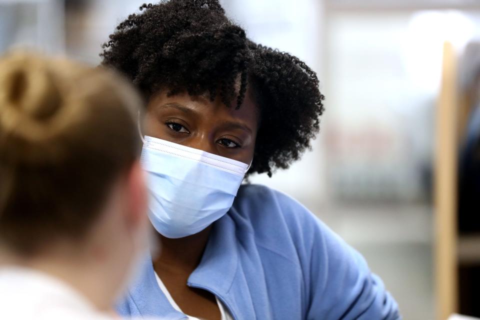 Vanessa Jean-Baptiste, a registered nurse in the intensive care unit at Northern Westchester Hospital in Mount Kisco, gets an update on patient information from fellow nurse Kate D'Angelone at the beginning of Jean-Baptiste's 12-hour shift on Feb. 28, 2022.