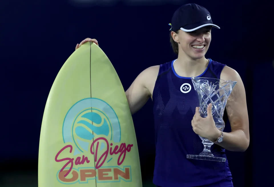 La polaca Iga Swiatek posando con su trofeo y una tabla de surf tras derrotar a Donna Vekic en la final del Abierto de San Diego. Foto: Getty