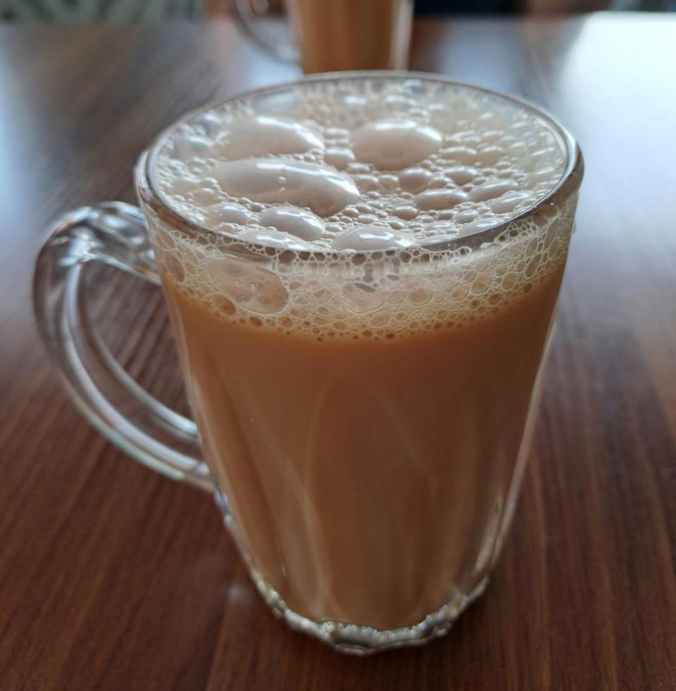 A glass of teh tarik, tea that is pulled to create froth at the top of the cup.