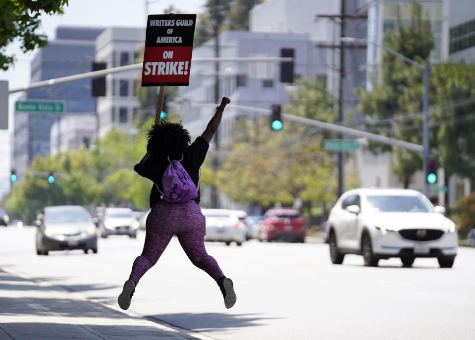 Ambrit Millhouse, a writer for the television series "Abbott Elementary," leaps as she participates in a Writers Guild rally in front of The Walt Disney Company studio, Wednesday, May 17, 2023, in Los Angeles. (AP Photo/Chris Pizzello)