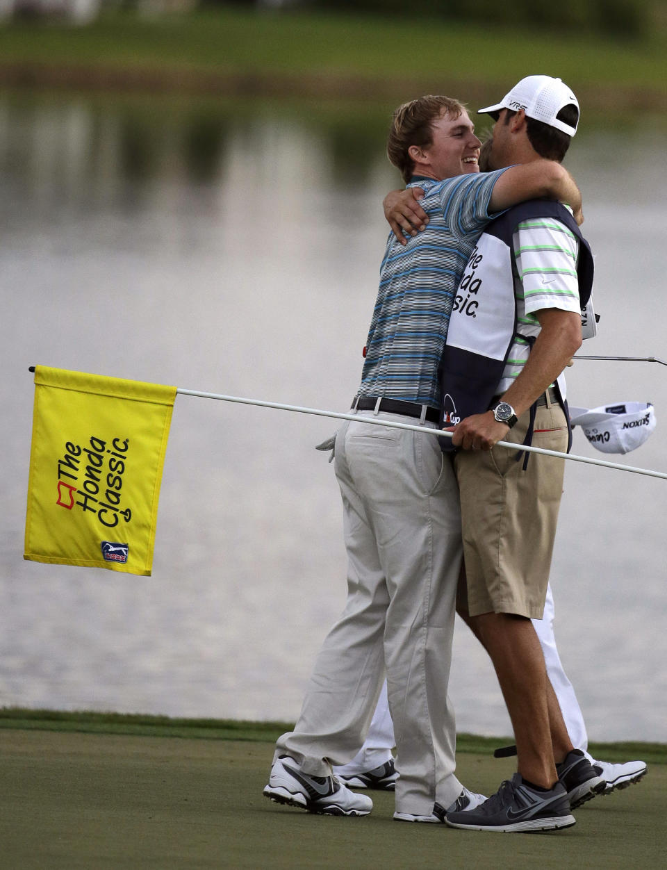 Russell Henley, left, hugs his caddie after winning a four-way playoff on the 18th hole to win the Honda Classic golf tournament on Sunday, March 2, 2014, in Palm Beach Gardens, Fla. (AP Photo/Lynne Sladky)