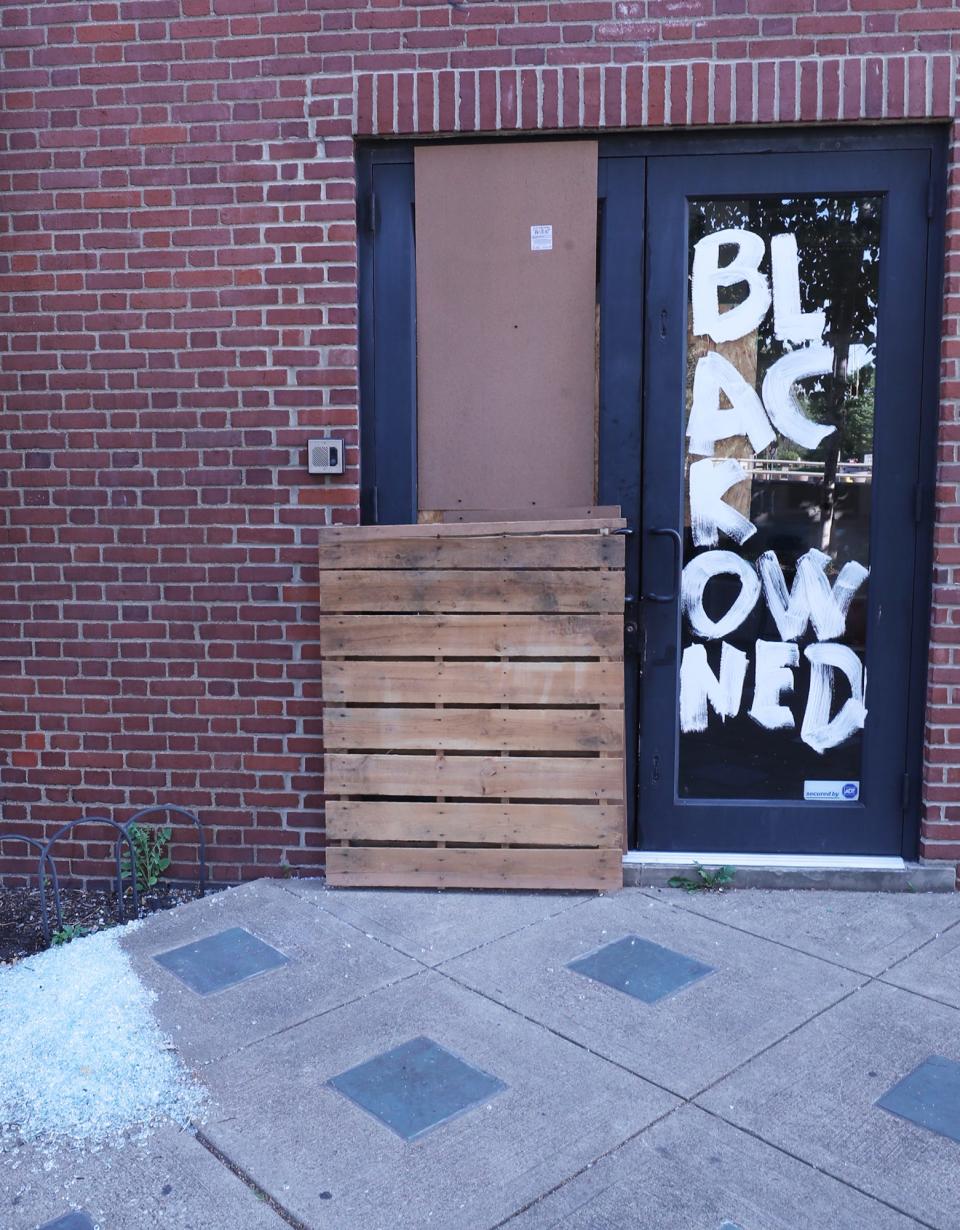 A Black-owned business sign painted on a door didn't prevent protesters from breaking a window during protests of the police shooting of Jayland Walker Sunday night in Akron.
