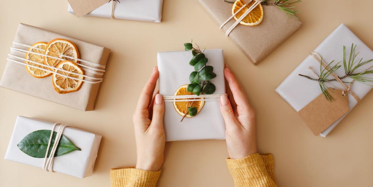 hands holding a gift surrounded by other presents