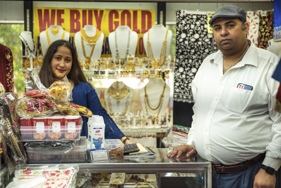 Lolith Lima Rodrigues, left, and Chander Shekhar, co-owners of Shopno Fashion in New York's Jackson Heights neighborhood, pose for a portrait on June 22, 2020, the first day of New York City's "Phase Two" reopening plan. This neighborhood was hit particularly hard by COVID-19, and as shops opened for the first time in more than three months, no one knew what lay ahead. (AP Photo/Marshall Ritzel)