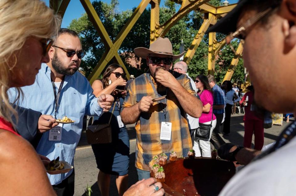 Attendees try a dish of fresh tuna marinated in coconut cream and served on a crispy confit taro root by Chef T’s Kitchen at the Tower Bridge Dinner on the Tower Bridge between Sacramento and West Sacramento on Sunday.