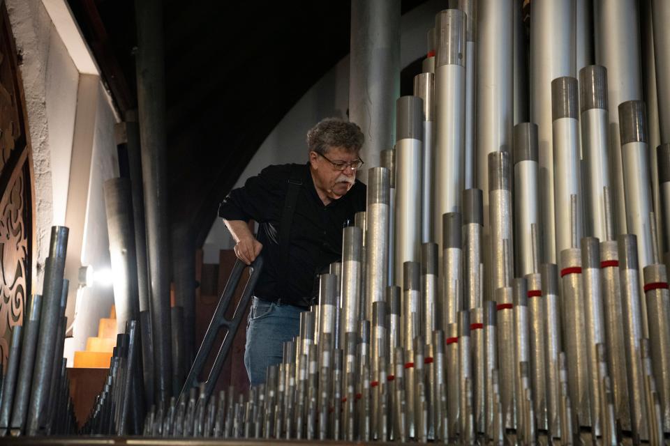 Mark Wright, music director at Christ Episcopal Church, works to repair a pipe organ on Tuesday, May 9, 2023. The organ was damaged during a 1978 Christmas Eve arson and from years of neglect. 