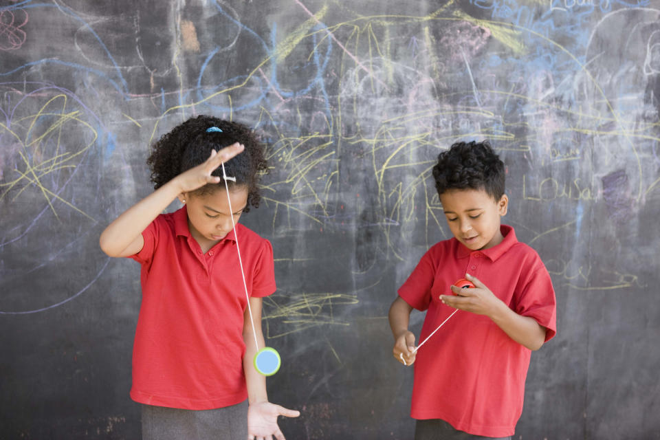 Two children playing with yo-yos