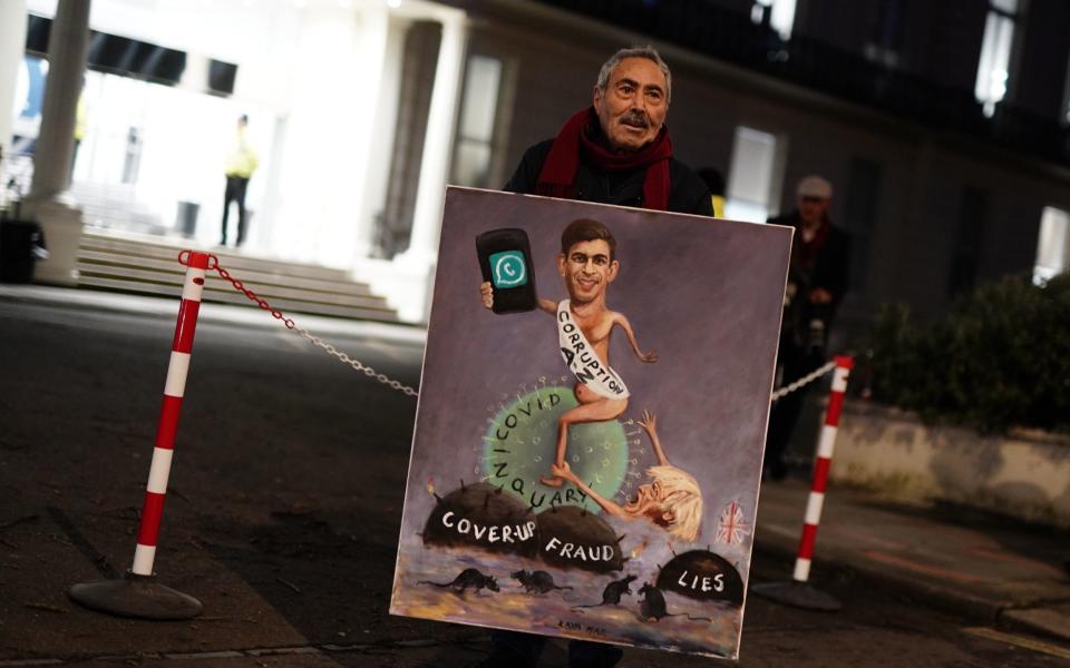 Political artist Kaya Mar with a painting of Prime Minister Rishi Sunak and former prime minister Boris Johnson outside the UK Covid Inquiry