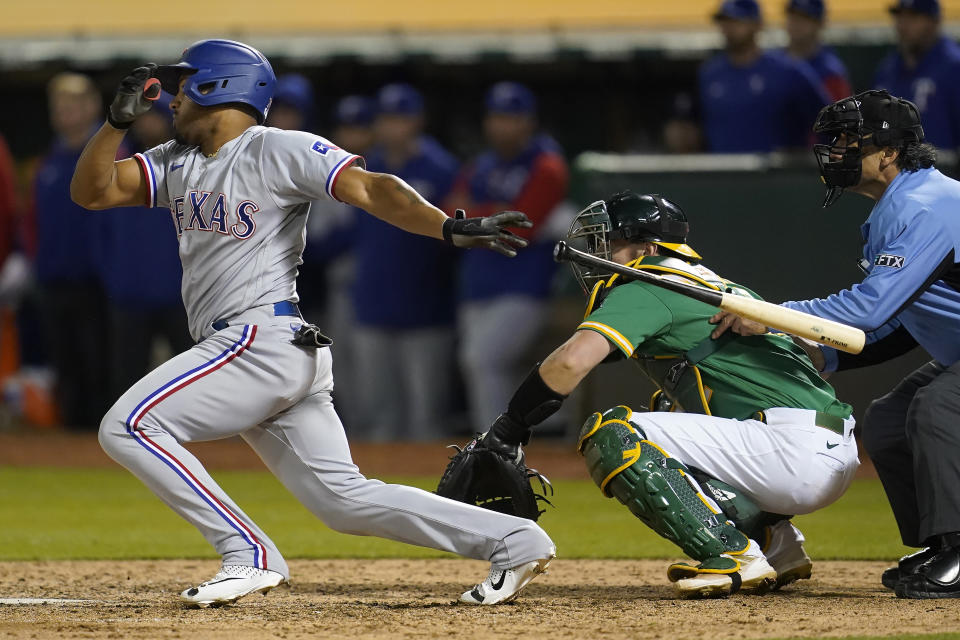 Texas Rangers' Andy Ibanez watches his two-run single in front of Oakland Athletics catcher Sean Murphy during the ninth inning of a baseball game in Oakland, Calif., Friday, May 27, 2022. (AP Photo/Jeff Chiu)