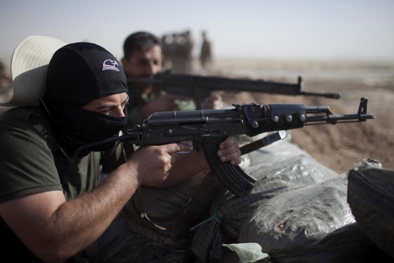 Kurdish Peshmerga fighters hold a position on the frontline in Yangije, where heavy clashes against Islamic States (IS) fighters took place the previous night, 50 kms east of Tikrit, September 11, 2014