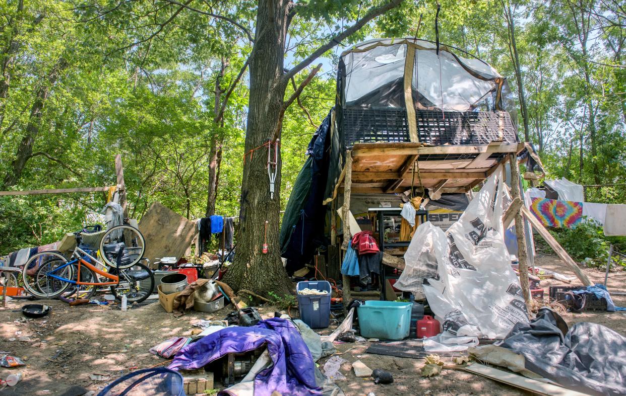 A homemade loft structure is surrounded by tarps, plastic sheeting and other items at a homeless encampment near the Landmark Recreation Center in Peoria.