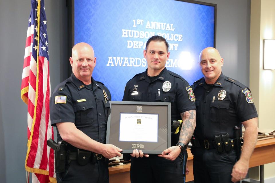 Hudson Police Officer Kevin Johnson (center), is currently suspended while he's been charged with domestic violence charges. Here, Johnson is pictured receiving the Hudson Police Department's Life Saving Award during the department's award ceremony.