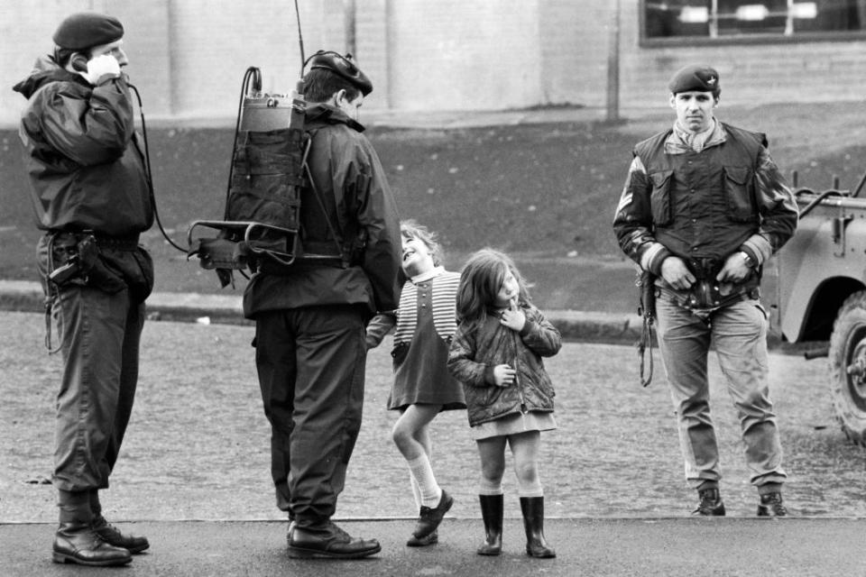 Two young girls stand with members of the British Army's Parachute Regiment in the primarily Catholic Divis Flats housing estate, Belfast, Northern, Ireland, August 10, 1969<span class="copyright">Leif Skoogfors/Corbis via Getty Images</span>