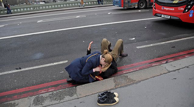 A woman assists a person injured in the attack in London on Wednesday. Photo: Reuters