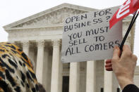 <p>A woman holds up a sign as people gather outside of the Supreme Court which is hearing the ‘Masterpiece Cakeshop v. Colorado Civil Rights Commission’ today, Tuesday, Dec. 5, 2017, in Washington. (Photo: Jacquelyn Martin/AP) </p>