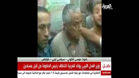 An undated still image aired by broadcaster Al Arabiya shows what it says is Libyan Prime Minister Ali Zeidan surrounded by men at an unidentified location. REUTERS/Al Arabiya via Reuters