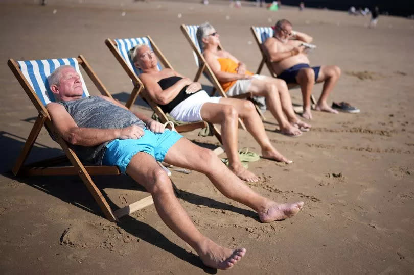 People enjoy the sunshine and high temperatures on the beach