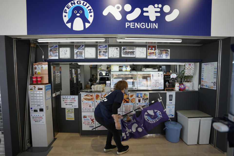 Fast food restaurant owner Atsuko Yamamoto prepares to open the shop in Futaba town, northeastern Japan, Wednesday, March 2, 2022. Yamamoto restarted Penguin, one of her family's old businesses, in 2020, when the community center opened for the public, as she wanted to help bring local people back together, as part of her way of the area reconstruction, following the 2011 earthquake. (AP Photo/Hiro Komae)