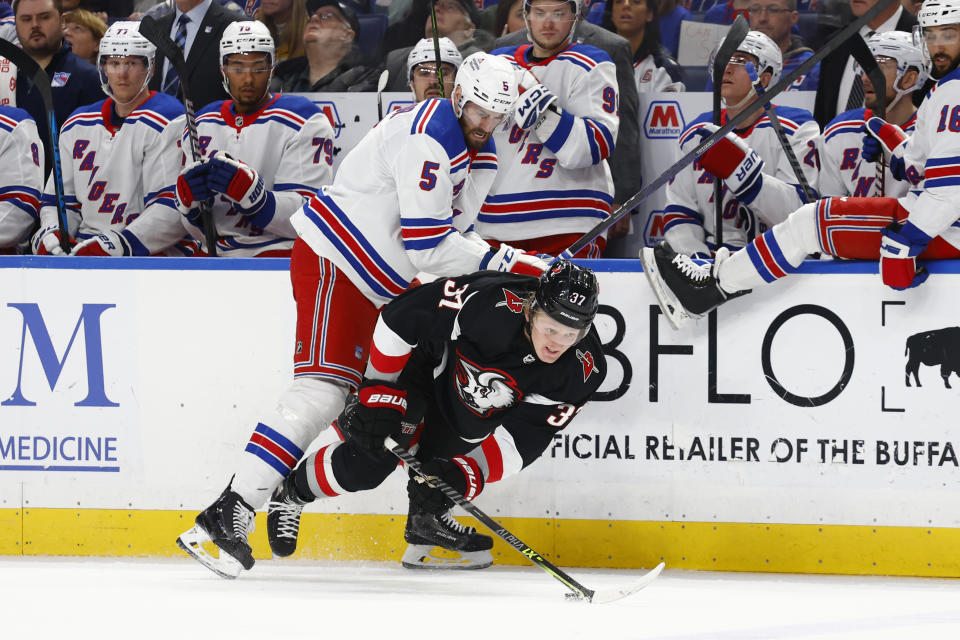 Buffalo Sabres center Casey Mittelstadt (37) is checked by New York Rangers defenseman Ben Harpur (5) during the second period of an NHL hockey game, Saturday, March 11, 2023, in Buffalo, N.Y. (AP Photo/Jeffrey T. Barnes)