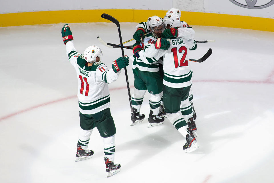 Minnesota Wild's Zach Parise (11), Jared Spurgeon (46), Kevin Fiala (22) and Eric Staal (12) celebrate a goal by Spurgeon against the Vancouver Canucks during the second period of an NHL hockey playoff game Sunday, Aug. 2, 2020, in Edmonton, Alberta. (Codie McLachlan/The Canadian Press via AP)