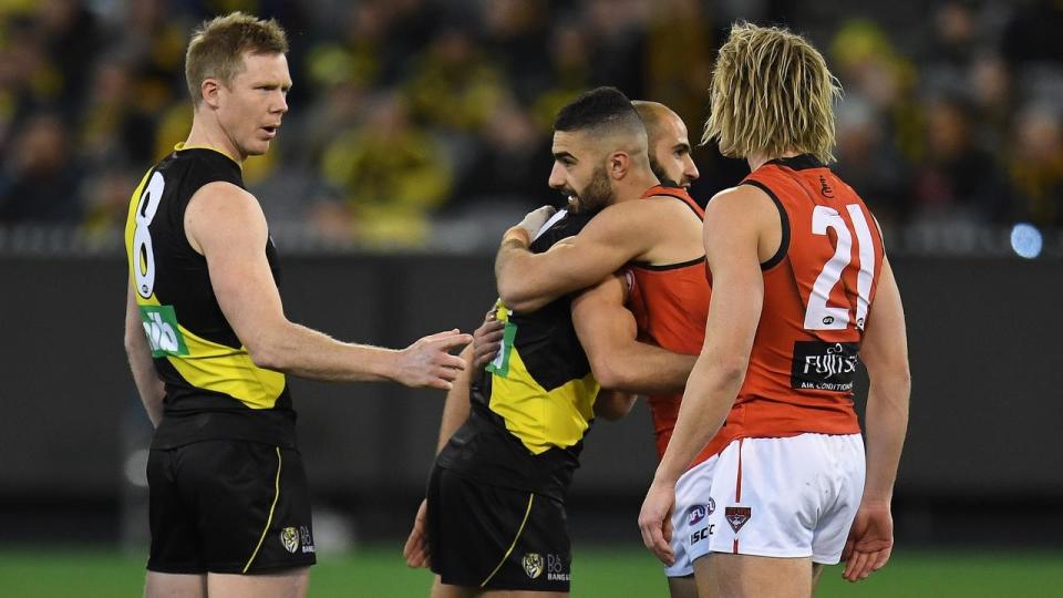 Bachar Houli and Adam Saad embraced after joining Jack Riewoldt and Dyson Heppell for the coin toss. Pic: AAP