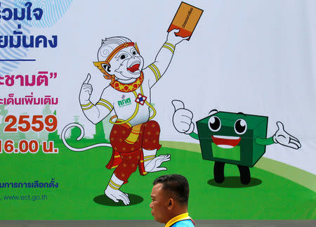 A man walks past a Thailand Election Commission's banner during an event to kick off the distribution of five million copies of a controversial military-written draft constitution, ahead of the August 7 referendum in Bangkok, Thailand, May 25, 2016. REUTERS/Chaiwat Subprasom