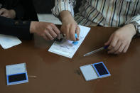 Staff members of a polling station prepare ballot papers for the Iranian presidential runoff election at a polling station in Tehran, Iran, Friday, July 5, 2024. Iranians began voting Friday in a runoff election to replace the late President Ebrahim Raisi, killed in a helicopter crash last month, as public apathy has become pervasive in the Islamic Republic after years of economic woes, mass protests and tensions in the Middle East. (AP Photo/Vahid Salemi)