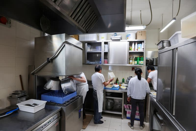 Migrants at work in the kitchen of a Milan restaurant