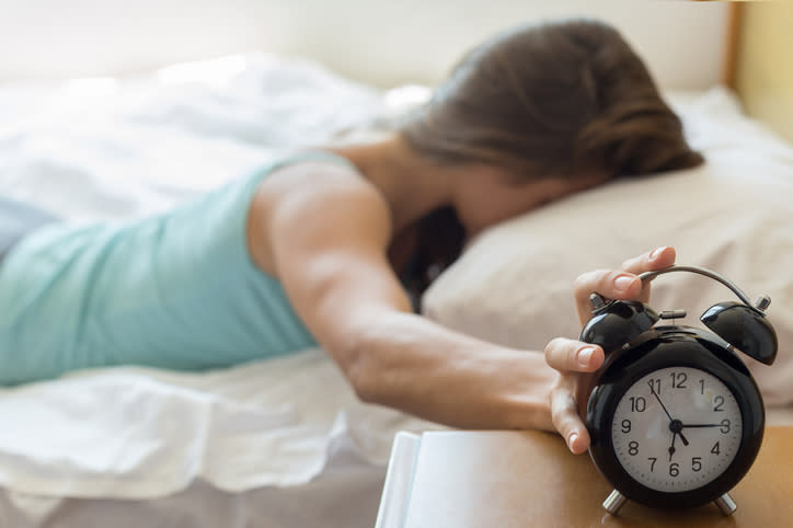 A girl is pictured touching her alarm clock.