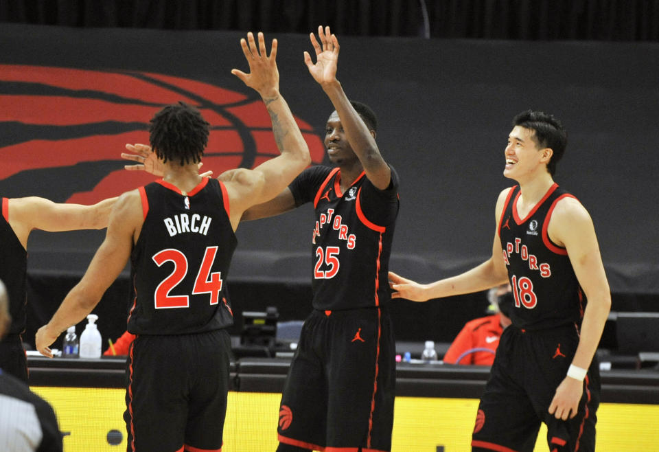 Toronto Raptors' Khem Birch (24) celebrates with Chris Boucher (25) and Yuta Watanabe (18) after Boucher scored a three-point basket late in the fourth quarter of a basketball game against the Oklahoma City Thunder, Sunday, April 18, 2021, in St. Petersburg, Fla. (AP Photo/Steve Nesius)