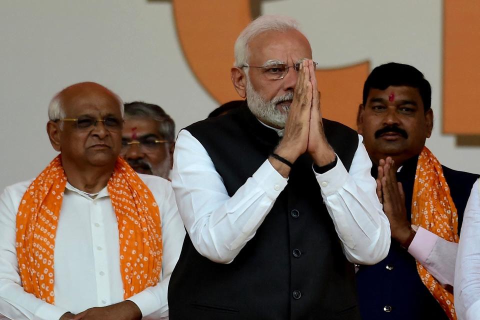 India's Prime Minister Narendra Modi (C) gestures during a swearing in ceremony of Gujarat Chief Minister Bhupendrabhai Patel (L) after Gujarat state assembly elections, in Gandhinagar, December 12, 2022. / Credit: SAM PANTHAKY/AFP/Getty