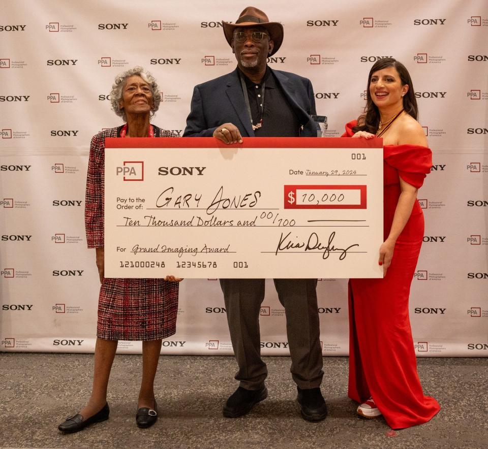 From left to right, Azzie L. Jones, her son Gary D. Jones and Kira Derryberry, Professional Photographers of America president, pose with the $10,000 prize check.