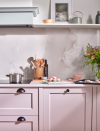 <p>We love this brave use of pink in the Ludlow kitchen at Magnet. Sophisticated stones such as quartz or marble make a great pairing for a more youthful and playful pastel. This combination would work wonderfully with any colour – picture pastel green cabinetry with a jade splashback for instance. </p><p>Pictured: <a href="https://www.magnet.co.uk/kitchens/ludlow/lilac-blossom--seagrass/" rel="nofollow noopener" target="_blank" data-ylk="slk:Ludlow Kitchen in Lilac Blossom & Seagrass at Magnet;elm:context_link;itc:0;sec:content-canvas" class="link ">Ludlow Kitchen in Lilac Blossom & Seagrass at Magnet</a></p>