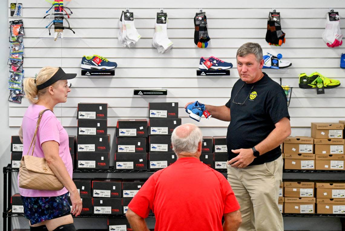 Owner Greg Stokes helps customers choose a pair of shoes available at Pickleball Sports at 4446 Forsyth Road In Macon. Jason Vorhees/The Telegraph