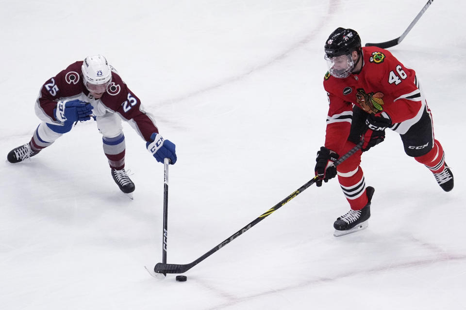 Colorado Avalanche right wing Logan O'Connor, left, and Chicago Blackhawks defenseman Louis Crevier, right, battle for the puck during the first period of an NHL hockey game in Chicago, Thursday, Feb. 29, 2024. (AP Photo/Nam Y. Huh)