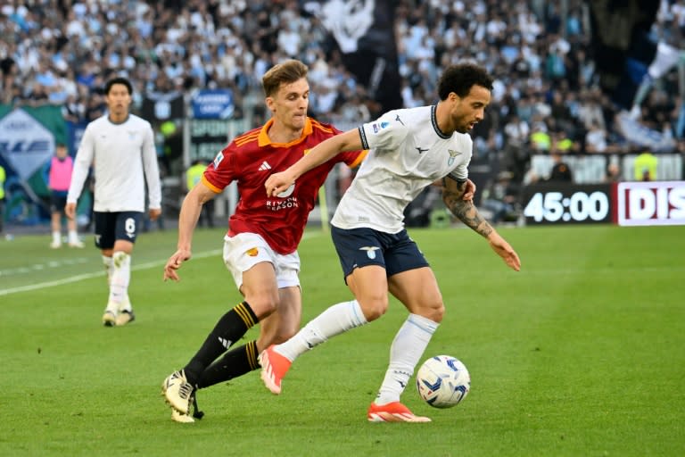 El defensa español de la Roma Diego Llorente lucha por el balón con el centrocampista brasileño de la Lazio Felipe Anderson durante un partido de fútbol de la Serie A italiana, disputado el 6 de abril de 2024 en el estadio Olímpico de Roma. (Alberto PIZZOLI)