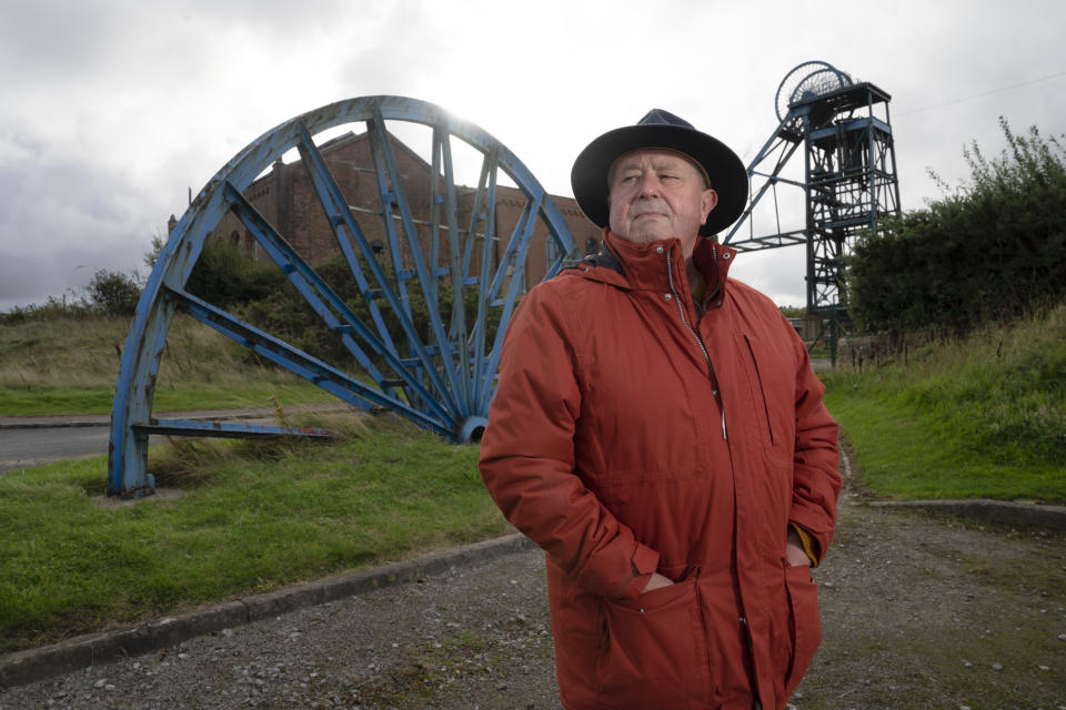 Former miner Dave Cradduck who worked at Haig Colliery between 1964 and 1984 poses for a picture at the Haig Colliery Mining Museum close to the site of a proposed new coal mine near the Cumbrian town of Whitehaven in northwest England, Monday, Oct. 4, 2021. For the 74-year-old Cradduck, a plan for a new coal mine that could bring hundreds of jobs is cause for hope. But environmentalists view it with horror. They say it sends a disastrous message as the United Kingdom welcomes world leaders, advocates, diplomats and scientists to Glasgow, Scotland, for a United Nations climate conference that starts Oct. 31. (AP Photo/Jon Super)