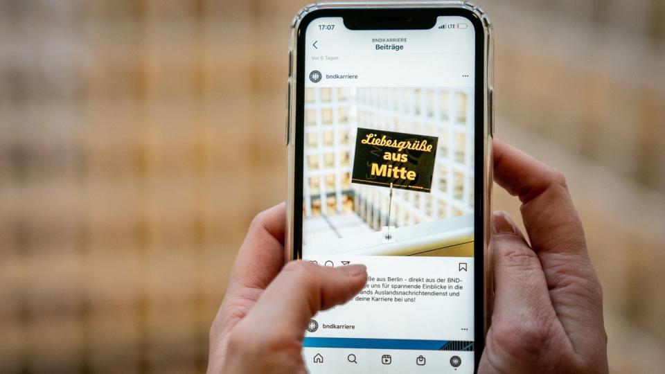 Eine BND-Mitarbeiterin zeigt einen Instagram-Post des deutschen Auslandsgeheimdienstes. (Bild: dpa)