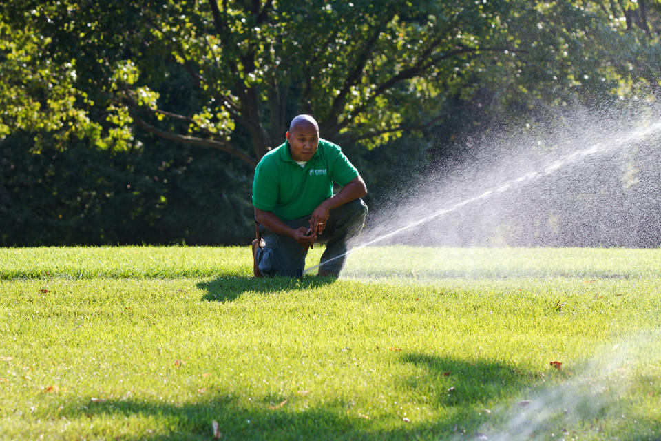 In this 2012 publicity photo provided by PLANET, a landscape professional checks for water distribution uniformity and makes sure the irrigation systems are installed and maintained properly. (AP Photo/PLANET, National Landscape Industry Association, Philippe Nobile)