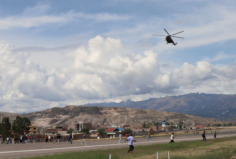 Foto de Archivo. Un helicóptero sobrevuela a manifestantes en la pista del aeropuerto en medio de violentas protestas tras el derrocamiento y arresto del expresidente Pedro Castillo, en Ayacucho, Perú.