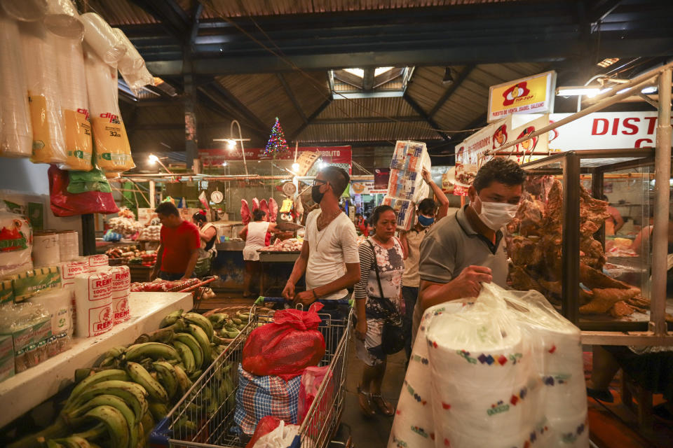 Clientes, algunos de ellos con mascarillas, compran en un mercado popular en Managua, Nicaragua, el 7 de abril de 2020. Los restaurantes están vacíos, hay poco tráfico en las calles y los bañistas escasean pese a ser Semana Santa aunque el gobierno pidió a los nicaragüenses que sigan con su vida pese a la pandemia de coronavirus. (AP Foto/Alfredo Zúñiga)