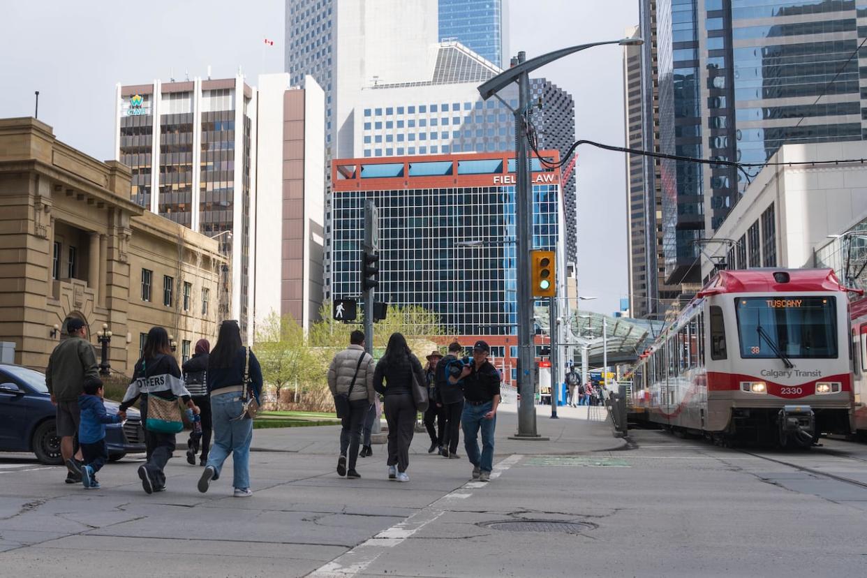 People and vehicles move through downtown Calgary on May 4, 2024.   (Ose Irete/CBC - image credit)