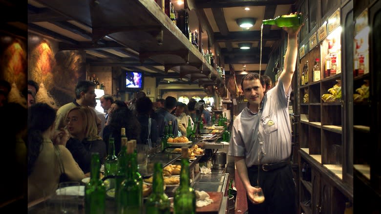 Asturian bartender pouring cider