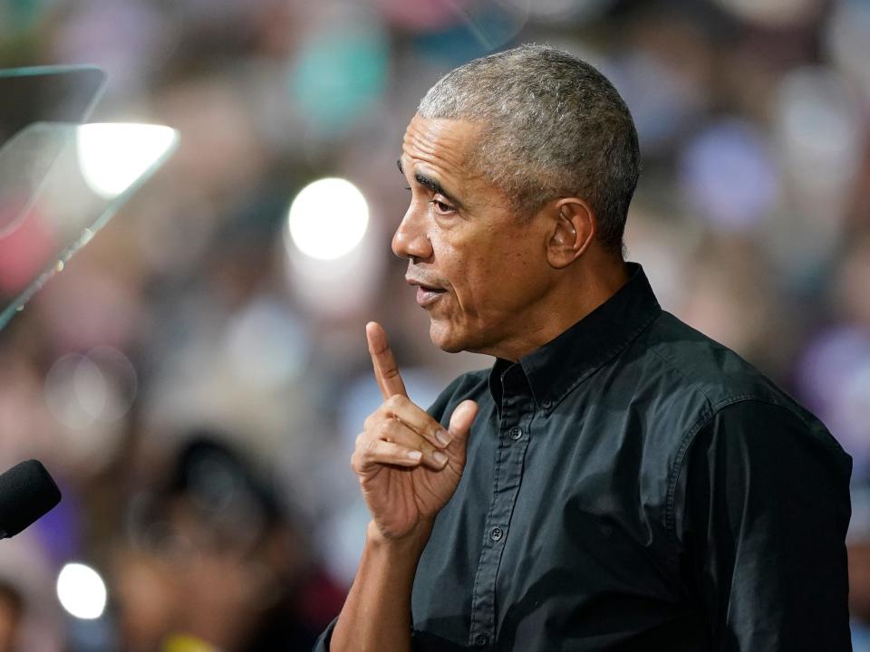 President Barack Obama standing at a podium and speaking with his finger raised in a questioning manner.